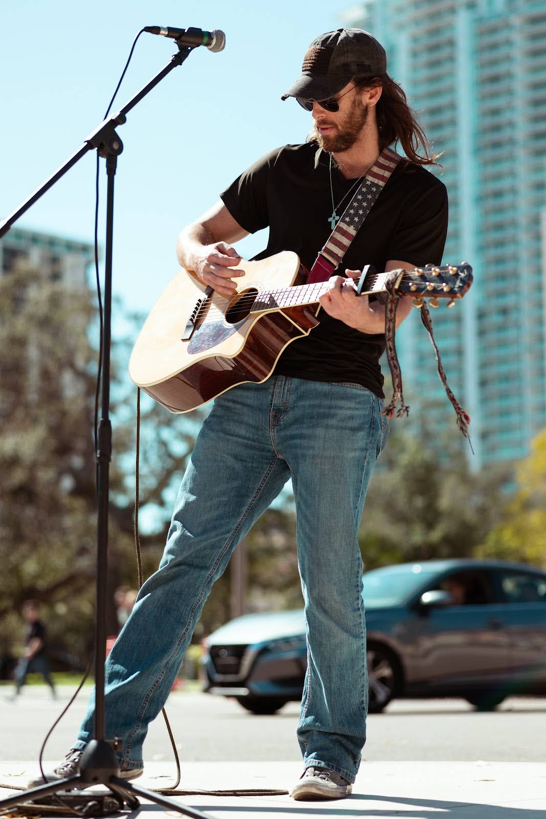 Mark Marra performing live outdoors with guitar